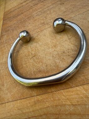 Silver tone heavy torque bangle bracelet.